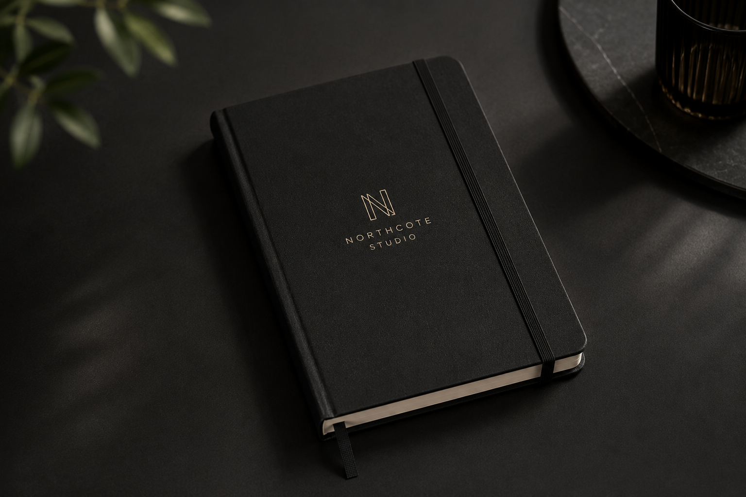 Closed Northcote Studio notebook on a black desk